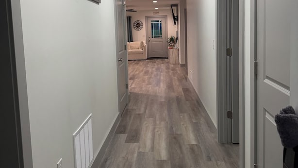 A hallway with a wooden floor, white walls, and a ceiling with a light fixture. -  "Last Light", This Perfect 3-bedroom, 2 bath cottage in quaint GOTL. (Geneva)