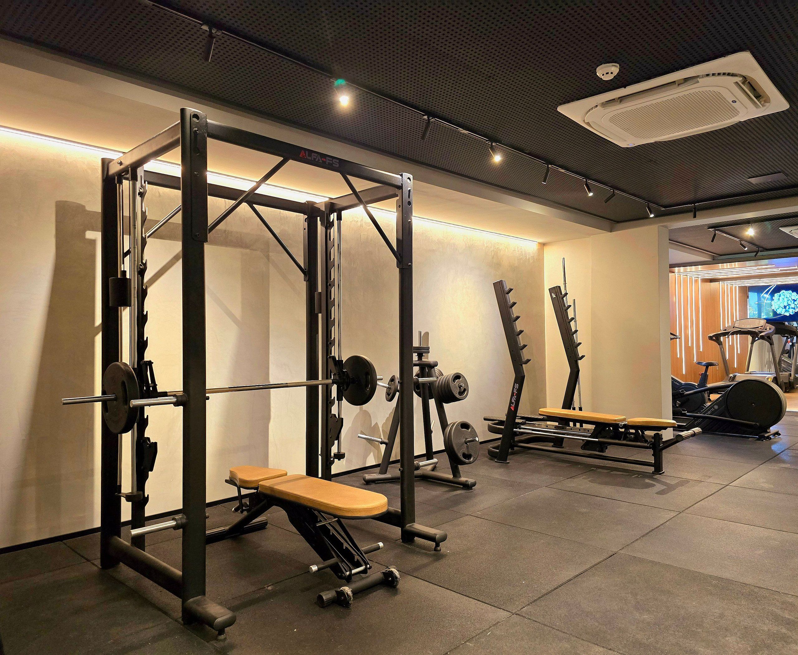 A gym with weightlifting equipment, treadmills, and exercise bikes.
