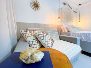 Una habitación moderna con un sofá, una pequeña mesa con una roca y una lámpara colgante.