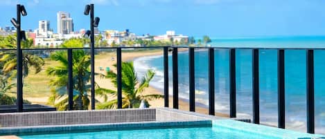 An infinity pool with a view of the beach and ocean.