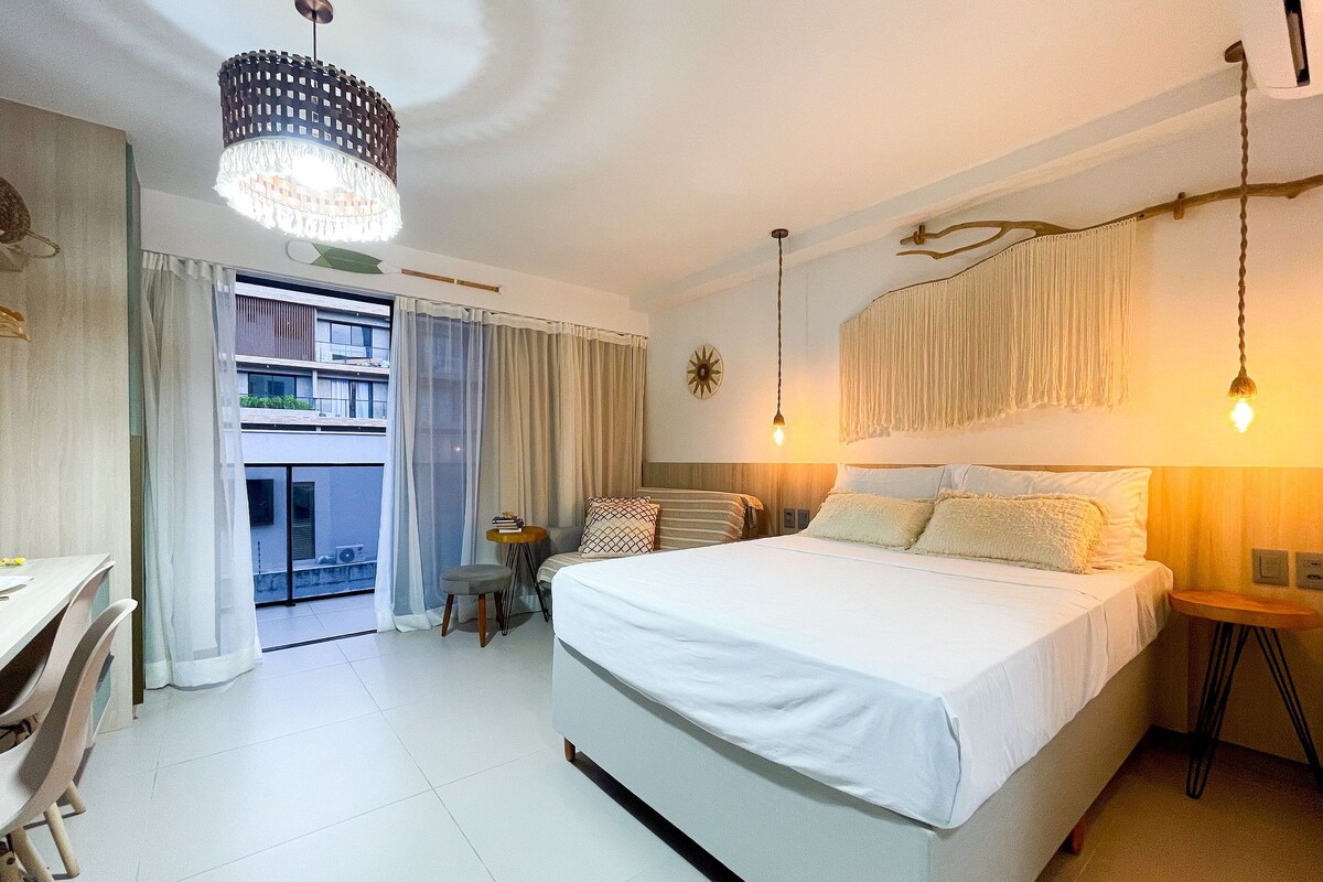 Une chambre d’hôtel avec un grand lit, un bureau et un balcon.