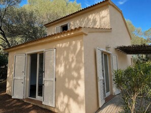 A two-story house with a flat roof, white shutters, and a small balcony. - Villa with a pool near Palombaggia Beach (Porto-Vecchio)