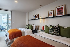 A hotel room with two beds, a balcony with chairs, and a city view. - Group Friendly | Private Terrace & BBQ in Roma Sur (Mexico City)