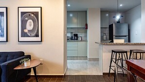 A modern apartment with a living room, a kitchen, and a dining area.