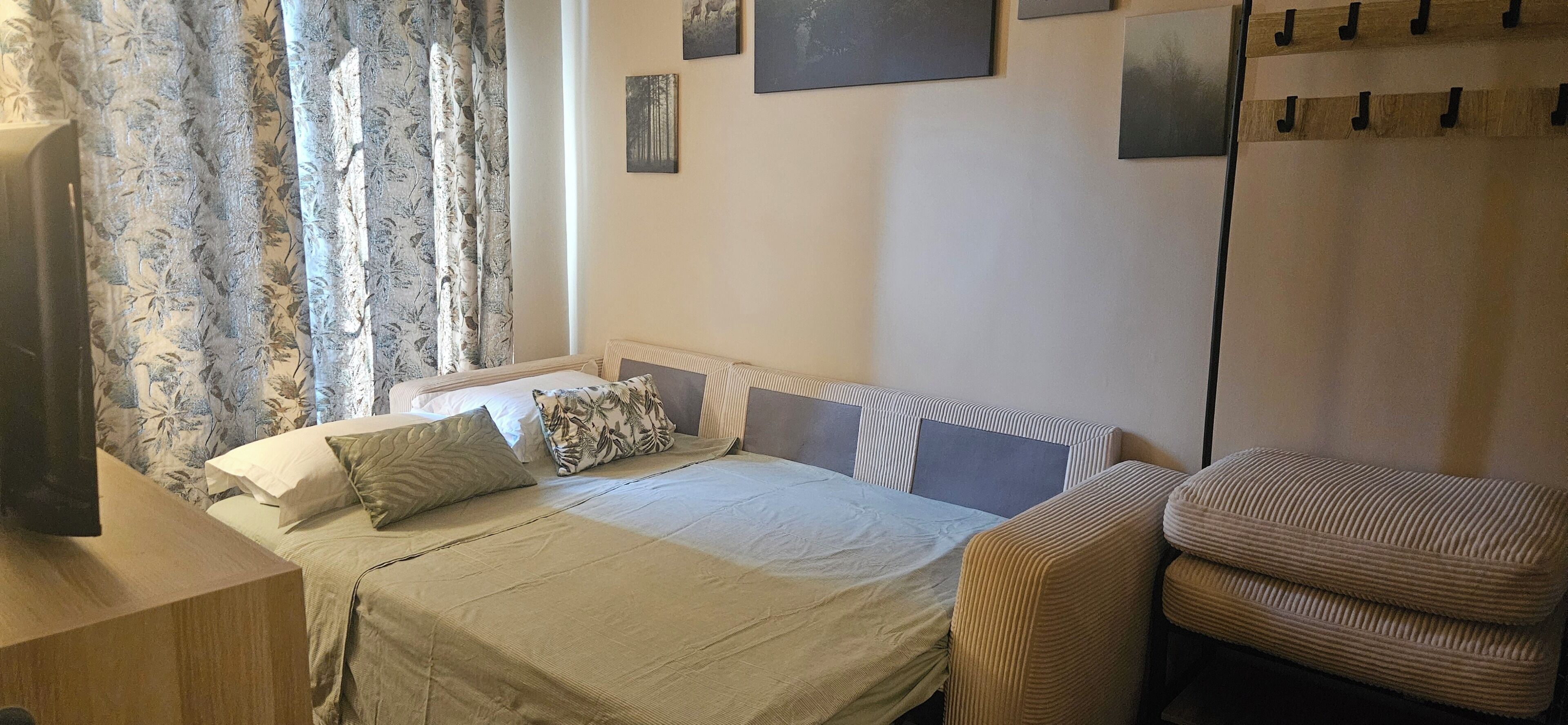 A bedroom with a bed, a chair, and a wardrobe.