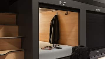 Een hotelkamer met een grote spiegel, een koffer en een boek getiteld '1000 dingen om in Londen te doen' op het aanrecht.