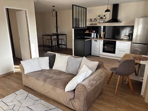 A modern apartment with a living room, kitchenette, and dining area. - Comfortable 2-bedroom apartment – Pavie (just outside Auch) – Sleeps 4 (Pavie)