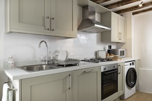 Eine moderne Küche mit Edelstahlgeräten, einem Backofen und einer Mikrowelle.