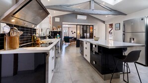 Una cocina moderna con una isla central, horno empotrado y tragaluz.