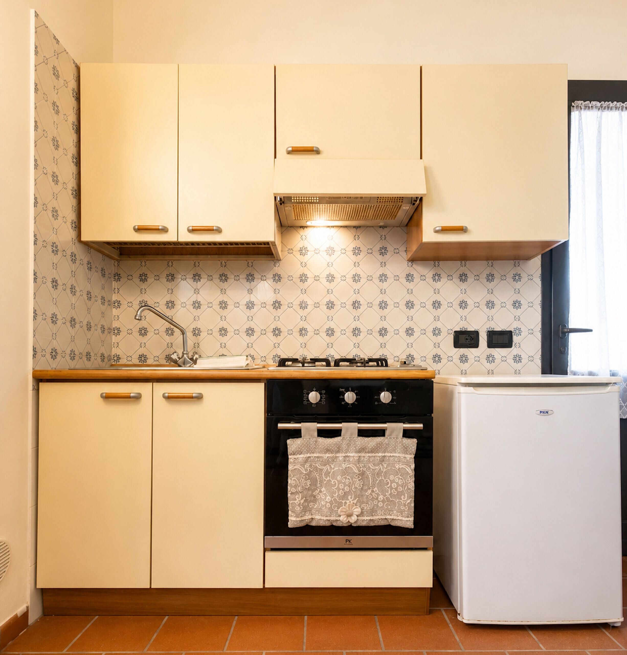 A compact kitchen with a stove, oven, and a refrigerator.