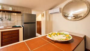 A kitchen with a refrigerator, a sink, and a countertop with a decorative plate. - Gaetano Spadaro Estate, Pendolino Apartment (Capannori)