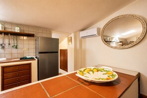 Eine Küche mit Kühlschrank, Spüle und einer Arbeitsplatte mit dekorativem Teller.