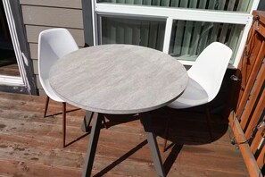 A round table with two white chairs on a wooden deck. - Family Vacation Home - DWTN - Airhockey - Spacious (Vancouver)