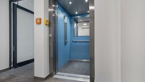 An elevator with a blue interior and a metallic door.