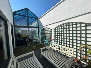 Eine moderne Außenpatio mit Glasveranda, Sitzgelegenheit und einem Fahrrad.