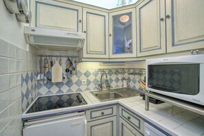A compact kitchen with a microwave, sink, and gas stove. - House with garden and jacuzzi - near city center (Saint-Tropez)