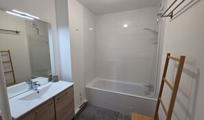 Ein modernes Badezimmer mit Waschbecken, Spiegel und Dusche.