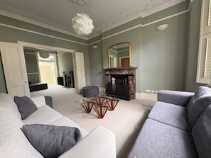 A living room with a fireplace, a sofa set, and a dining table. - Chiswick house close to tube and amenities (London)