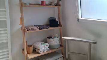 A wooden shelf with folded towels, a potted plant, and a sign reading 'FACTORY I.S. PORT AUTHORITY.'