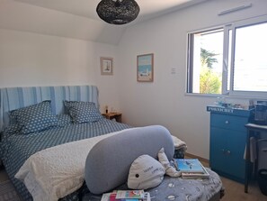 A bedroom with a bed, a nightstand, a window, and a desk with a computer. - Guesthouse 'Paloma à la Mer' 150m from the beach with terrace, garden and Wi-Fi (Pornichet)