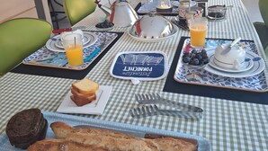 A breakfast setup with a table set for two, including plates, cutlery, a kettle, and a variety of breakfast items. - Paloma by the Sea Guest Room with Shared Terrace, Garden, and Wi-Fi (Pornichet)