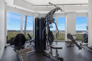 A gym with various exercise equipment, large windows, and a view of the beach. - Lighthouse 1414 - Owner Managed, Fully Updated. Beautiful 3BR Gulf Front Condo. (Gulf Shores)