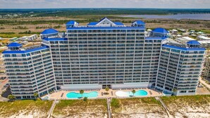 Ein großes Hotel mit mehreren Etagen, einem zentralen Innenhof mit Schwimmbad und Blick auf die umliegende Landschaft.