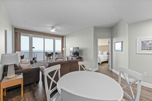 A modern hotel room with a balcony, a dining area, and a bedroom. - Lighthouse 1414 - Owner Managed, Fully Updated. Beautiful 3BR Gulf Front Condo. (Gulf Shores)