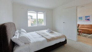 A bedroom with a bed, a window, a door, and a view of the outside. - Stylish Brunswick Retreat Free Parking Near CBD (Brunswick)
