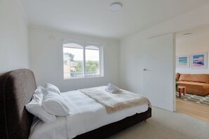 A bedroom with a bed, a window, a door, and a view of the outside. - Stylish Brunswick Retreat w Free Parking Near City (Brunswick)