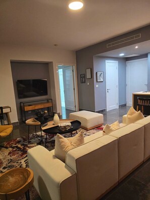 Ein modernes Wohnzimmer mit einer Couch, einem Fernseher und einem Essbereich.