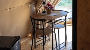 Une pièce aménagée avec une tente, une table, des chaises et un arrangement floral.