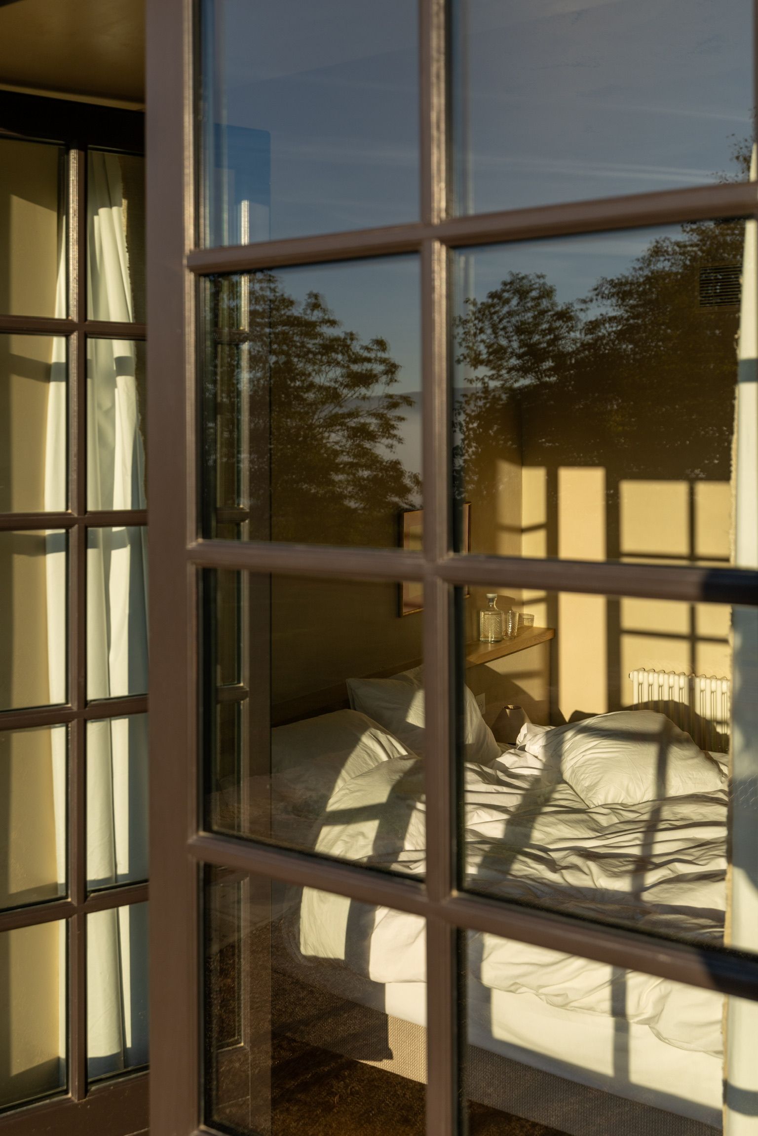 Une chambre à coucher avec un lit, une table de chevet et une fenêtre avec des rideaux.