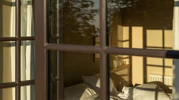 Une chambre à coucher avec un lit, une table de chevet et une fenêtre avec des rideaux.