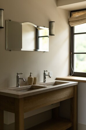 A bathroom with a wooden vanity, a mirror, two wall-mounted lights, and a window with a view. - AUBERGE DE MARIGNA (Marigna-sur-Valouse)