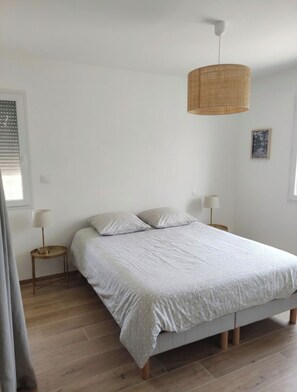 A bedroom with a bed, bedside lamps, a hanging light fixture, and a framed picture on the wall. - House nestled among the pine trees between Cadenet and Lourmarin, with a pool (Cadenet)