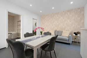 Ein modernes Wohnzimmer mit Essbereich, einer Couch und einem Couchtisch.