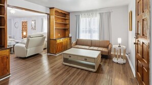 Un salon spacieux avec un canapé, une table basse et un meuble en bois.
