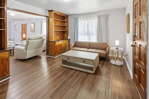 Un salon spacieux avec un canapé, une table basse et un meuble en bois.