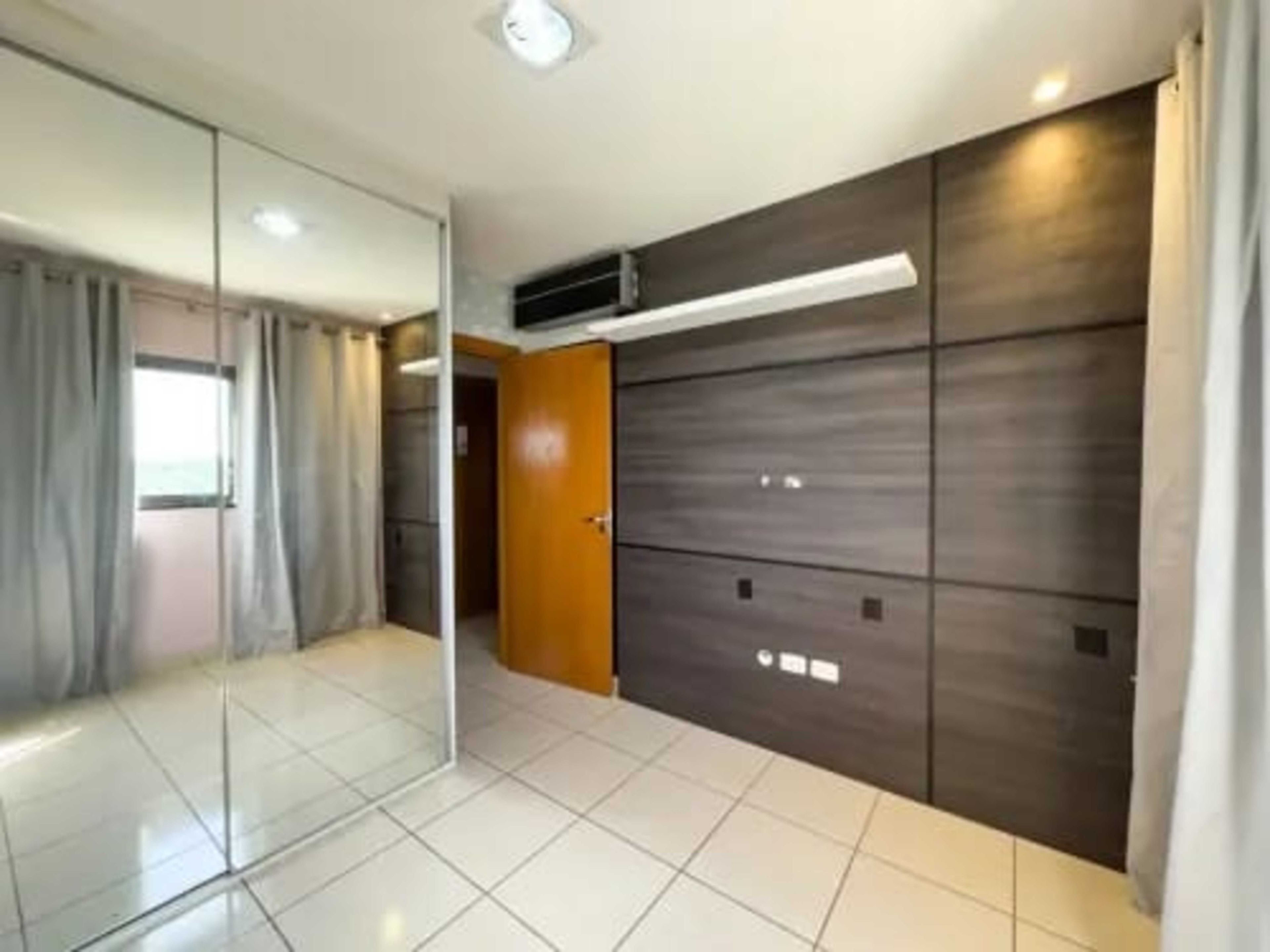 Una habitación con separador de vidrio, armario de madera y piso con baldosas.