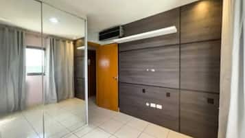 Una habitación con separador de vidrio, armario de madera y piso con baldosas.