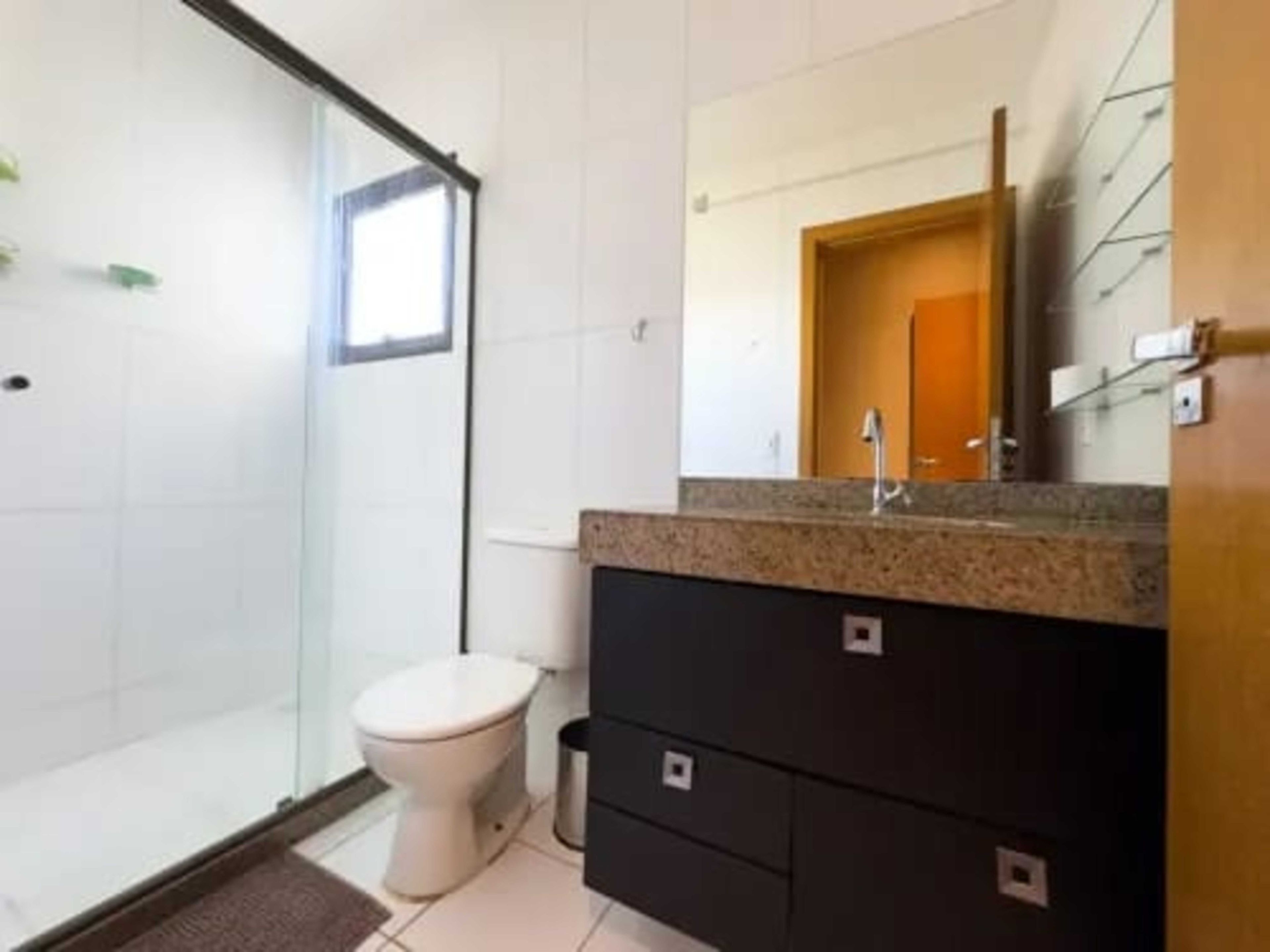 Une salle de bain avec des toilettes, un lavabo et un miroir.