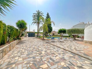 A tiled patio area with a pool and lounge chairs. - Villa Las Marinas CF with Private Pool near the Beach in Dénia (Denia)