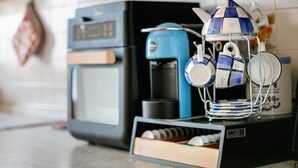 Une cuisine équipée d’une machine à café, d’une bouilloire et d’un porte-tasses.