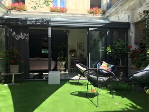 A private garden with artificial grass, a bed, and two chairs. - Guest Rooms in the Heart of Cognac – la maisonbyyann (Cognac)