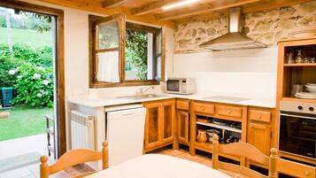 Una cocina con armarios de madera, microondas y lavavajillas.