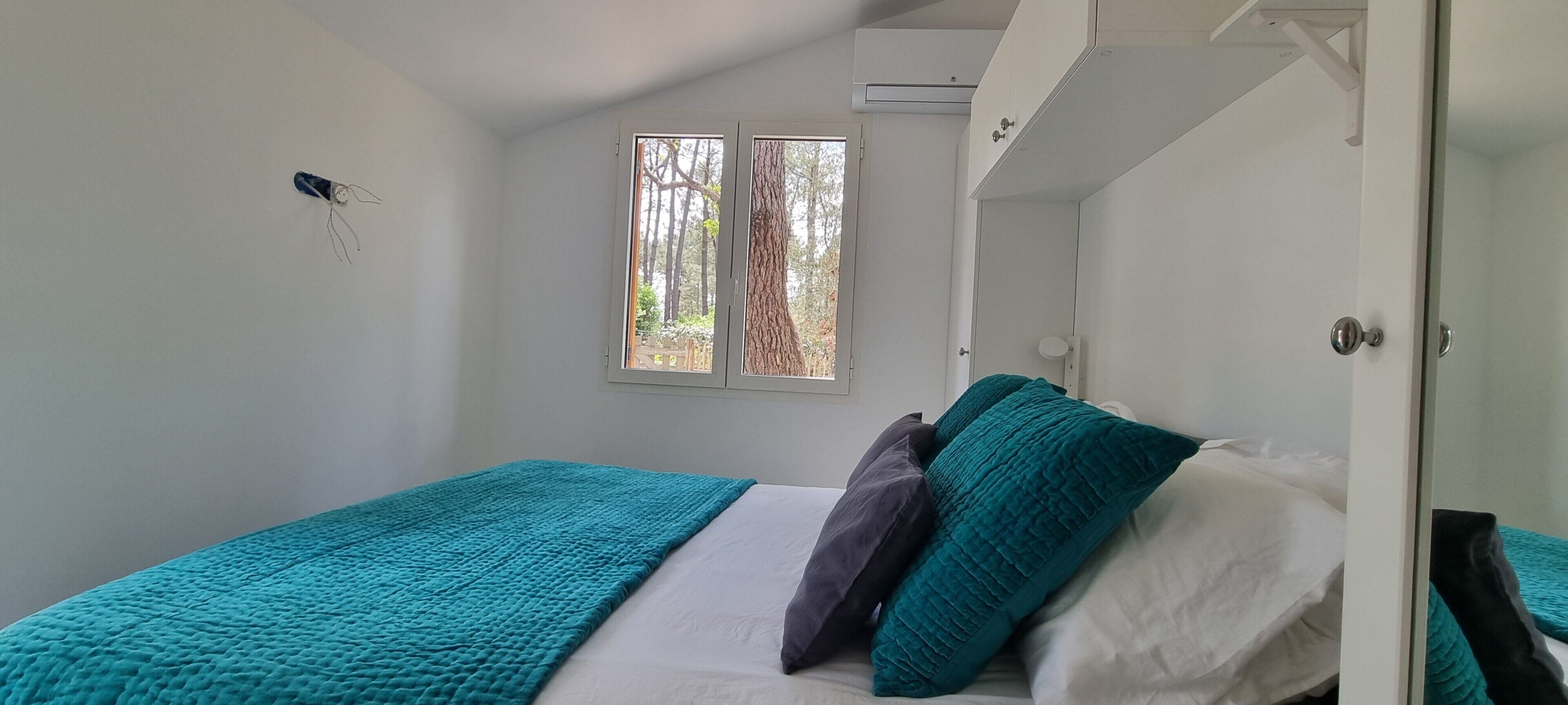 Ein Schlafzimmer mit einem Einzelbett, einem Fenster und einer Tür.