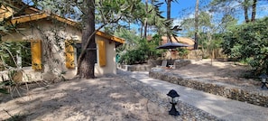 Un patio con un sendero de piedra, una cerca de madera y una zona de estar cubierta con una sombrilla.