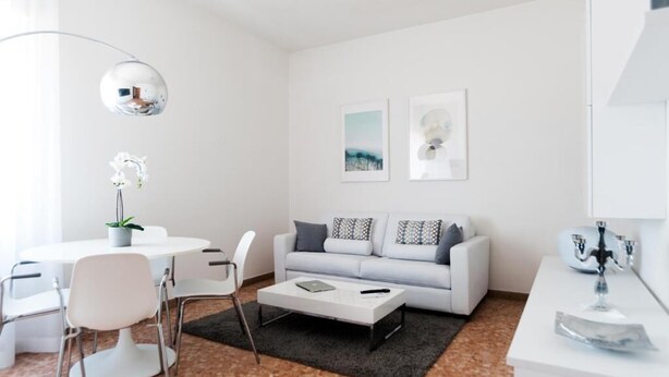 A modern living room with a white sofa, a round table, and a coffee table. - Fly by Suites Pescara (Pescara)
