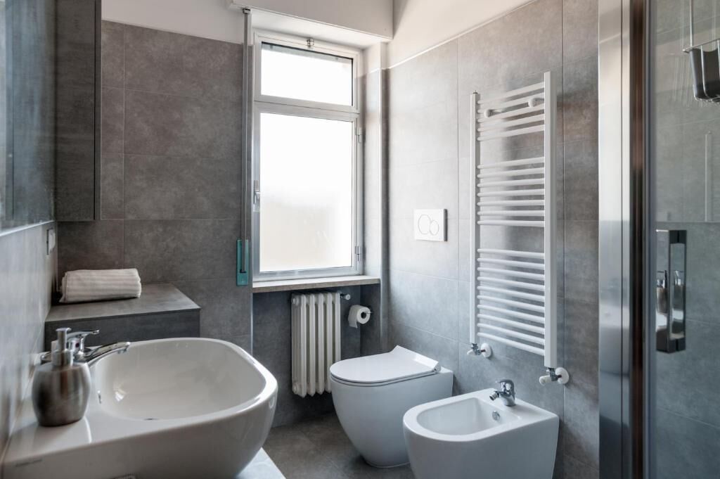 A modern bathroom with a large bathtub, a toilet, and a bidet.